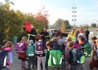 Viele Schulkinder von hinten, zwei Feuerwehrleute verteilen Rucksackcover