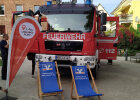 Feuerwehrauto, im Vordergrund Liegestühle der Raiffeisenbank mit Surferflagge Lieblingsplatz