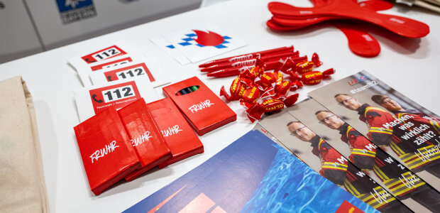 Giveaways des Bayerischen Innenministeriums und des Landesfeuerwehrverbands Bayern bei der Messe 'Heim + Handwerk' - © Sebastian Widmann / StMI Giveaways des Bayerischen Innenministeriums und des Landesfeuerwehrverbands Bayern auf Tisch