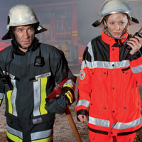 Ein Feuerwehrmann und eine Frau des BRK mit Digitalfunkgerät
